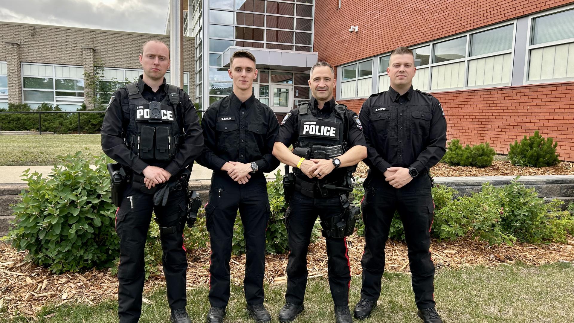 Grande Prairie Police Service officers stand in front of the RCMP detachment