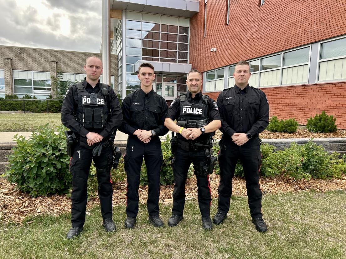 Grande Prairie Police Service officers stand in front of the RCMP detachment