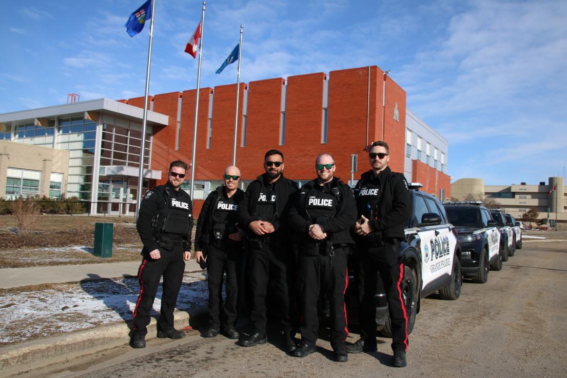 Grande Prairie Police Service members stand in front of the RCMP detachment.