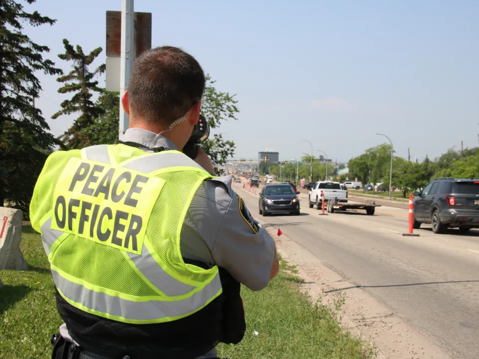 A Peace Officer operates a photo radar gun